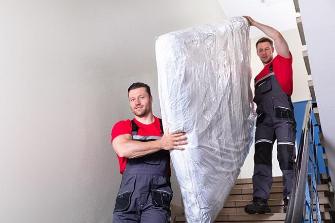 heavy lifting workers transporting a box spring out of a building in Burbank WA